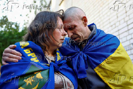 Ukrainian prisoner of war Oleksandr embraces his wife Olena as he returns after a swap in an undisclosed location in Ukraine