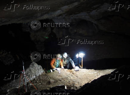 Researchers work in an excavation site where several dozen whale bone objects were discovered at the Basque cave of Isturitz