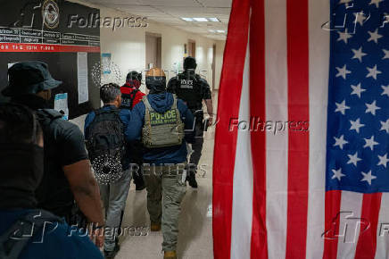A migrant is detained by federal immigration officers at U.S. immigration court