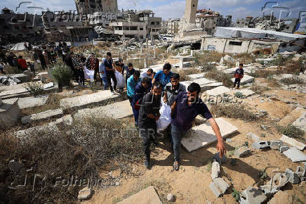 Mourners carry the bodies of members of the Al-Arabeed family killed in Israeli strikes, at a cemetery, in Gaza City