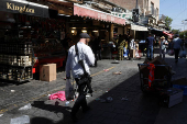 People shop in Jerusalem following an Israeli strike in Iran