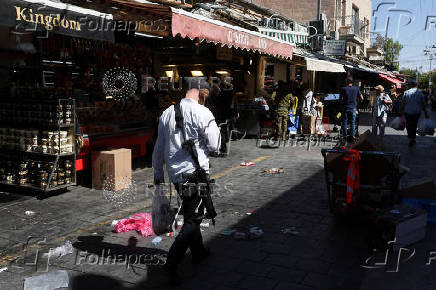 People shop in Jerusalem following an Israeli strike in Iran
