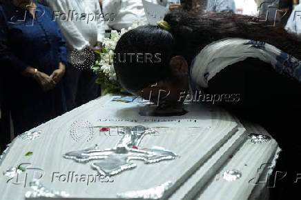 A relative mourns near the coffin of Co-Pilot Clive Kunder, who died after an AIR India Boeing 787-8 Dreamliner plane crashed during take-off from an airport in Ahmedabad, in Mumbai