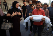 Mourners react near the body of a Palestinian killed in an Israeli strike, in Gaza City