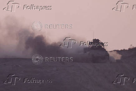 An armoured personnel carrier (APC) manoeuvres in Gaza, as seen from the Israeli side of the Israel-Gaza border