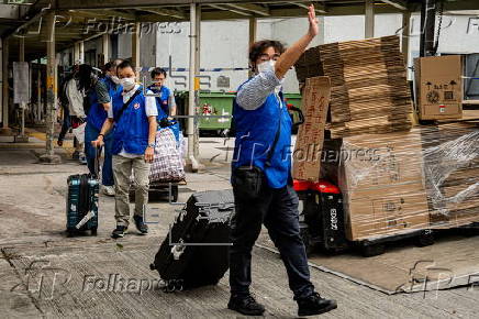 Hong Kong residents affected by the fire gather their belongings from their apartments