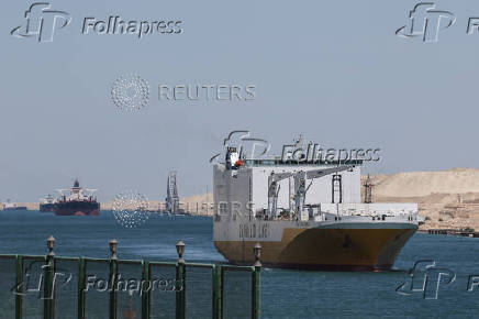 Ships move through the Suez Canal, on the Excellence Day, in Ismalia
