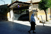 Druze woman walks near the Druze mosque in Jaramana