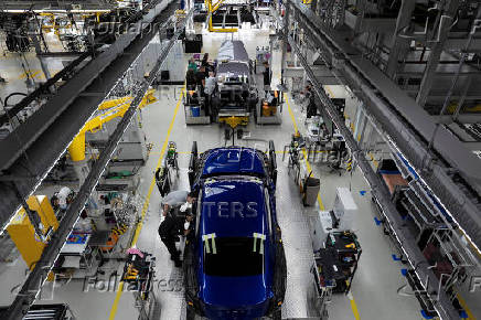 Technicians work on the assembly line for Rolls-Royce Cullinan and Spectre vehicles at Rolls-Royce Motor Cars' manufacturing plant in Goodwood