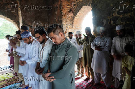 Muslims offer prayers at the ruins of the Feroz Shah Kotla mosque on the occasion of Eid al-Adha, in the old quarters of Delhi