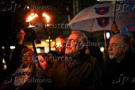 Argentine university teachers and students hold torches during a protest against Argentine President Javier Milei's education budget, in Buenos Aires