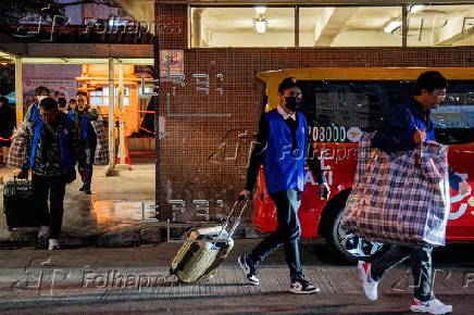 Hong Kong residents affected by the fire gather their belongings from their apartments