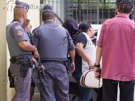 Adolescente suspeito (de capuz preto) de participar do planejamento do ataque em Suzano deixa o Fórum