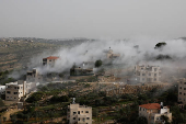 Smoke rises after the Israeli army blew up the house of a Palestinian assailant in Deir Ibzi town, near Ramallah