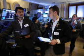Traders work on the floor at the New York Stock Exchange, in New York City