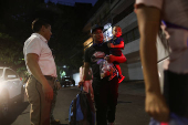 Migrants gather outside the Venezuelan embasssy waiting for a flight back to their country