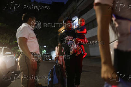 Migrants gather outside the Venezuelan embasssy waiting for a flight back to their country
