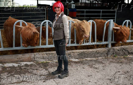 Farmer Fiona Wilson stands in front of cows who are a part of a herd of Highland Cattle at Dumble Farm in Arram