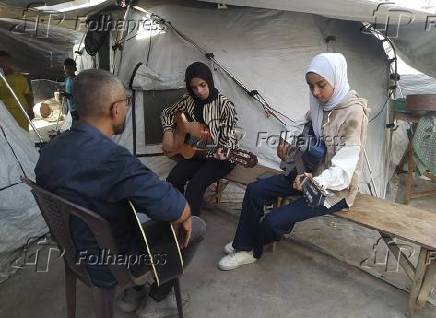 Crianças palestinas aprendem música para esquecer a guerra e a destruição.