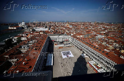 A large banner against Amazon founder Jeff Bezos lies on the ground in St. Mark's Square