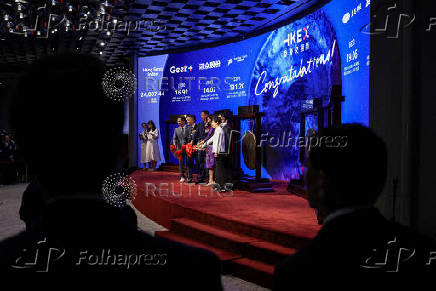 FILE PHOTO: Guests pose for photos during companies' listing ceremonies at the Hong Kong Stock Exchange in Hong Kong