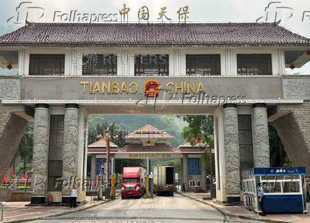 Container trucks cross the Tianbao port in Malipo county