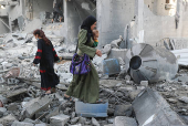 Palestinians inspect the damage at the site of an Israeli strike on a house, in Jabalia