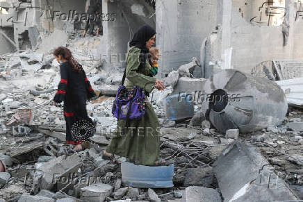Palestinians inspect the damage at the site of an Israeli strike on a house, in Jabalia