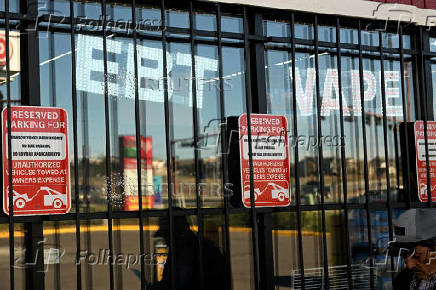 A lighted sign inside a convenience store states 