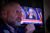 A trader works, as a screen broadcasts a news conference by U.S. Federal Reserve Chair Jerome Powell following the Fed rate announcement, on the floor of the NYSE in New York