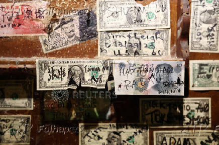 American dollars and Chinese yuan are displayed on a wall of a restaurant, Koror