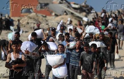 Palestinians carry aid supplies that entered Gaza through Israel, in Beit Lahia