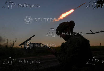 Members of the National Police Special Purpose Battalion fire a Partizan multiple rocket launcher towards Russian troops on a front line in Zaporizhzhia Region
