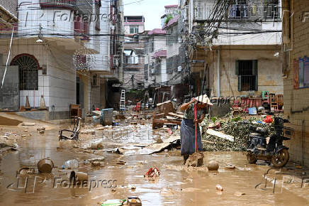 Resident cleans up a street after heavy rainfall led to flooding in Zhaoqing