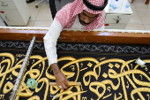 Workers prepare the Kiswa, a silk cloth that covers the Kaaba, ahead of the annual hajj pilgrimage