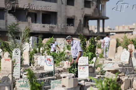 A person visits the cemetery, on the first day of the Muslim holiday of Eid al-Adha, in Damascus