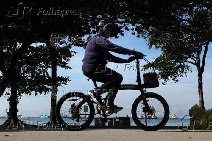 A woman rides a bike along East Coast Park in Singapore