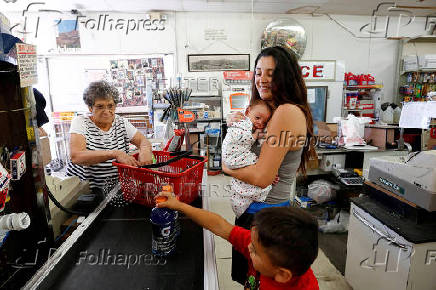 FILE PHOTO: Hernandez holds newborn at the Save Money Market checkout in the historic mining town of Superior, Arizona