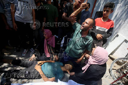 Palestinians gather around casualties of Israeli fire, who were seeking aid in northern Gaza, according to medics, in Gaza City