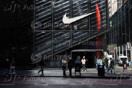People walk past a Nike store in New York