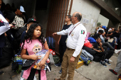 Migrants gather outside the Venezuelan embasssy waiting for a flight back to their country