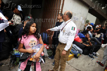 Migrants gather outside the Venezuelan embasssy waiting for a flight back to their country