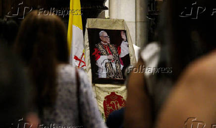 Fiéis rezam diante da imagem do Papa eleito Leão XIV  na catedral da Sé