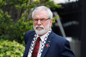 Former Sinn Fein President Gerry Adams sits outside the High Court, in Dublin