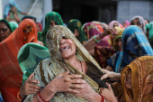 Family members and relatives mourn during the funeral of Chetnaba Chavda and her husband Ranvirsinh Chavda in Ahmedabad