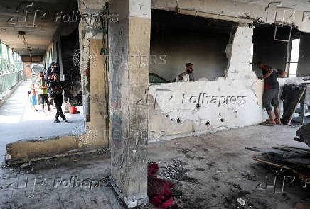 Palestinians inspect the damage following an overnight Israeli strike on a school sheltering displaced families, in Jabalia