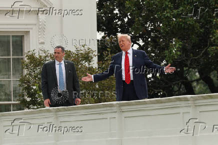 U.S. President Trump talks with architect McCrery as they walk on the roof of the White House in Washington