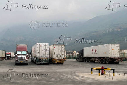Container trucks cross the Tianbao port in Malipo county