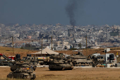 Military vehicles stand near the border with Gaza