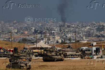 Military vehicles stand near the border with Gaza